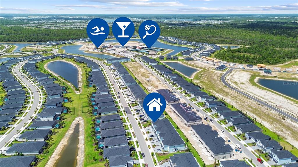 This aerial view shows a residential community with numerous houses, ponds, and recreational amenities — 14867 WHITE PEARL ROAD, PUNTA GORDA, FL