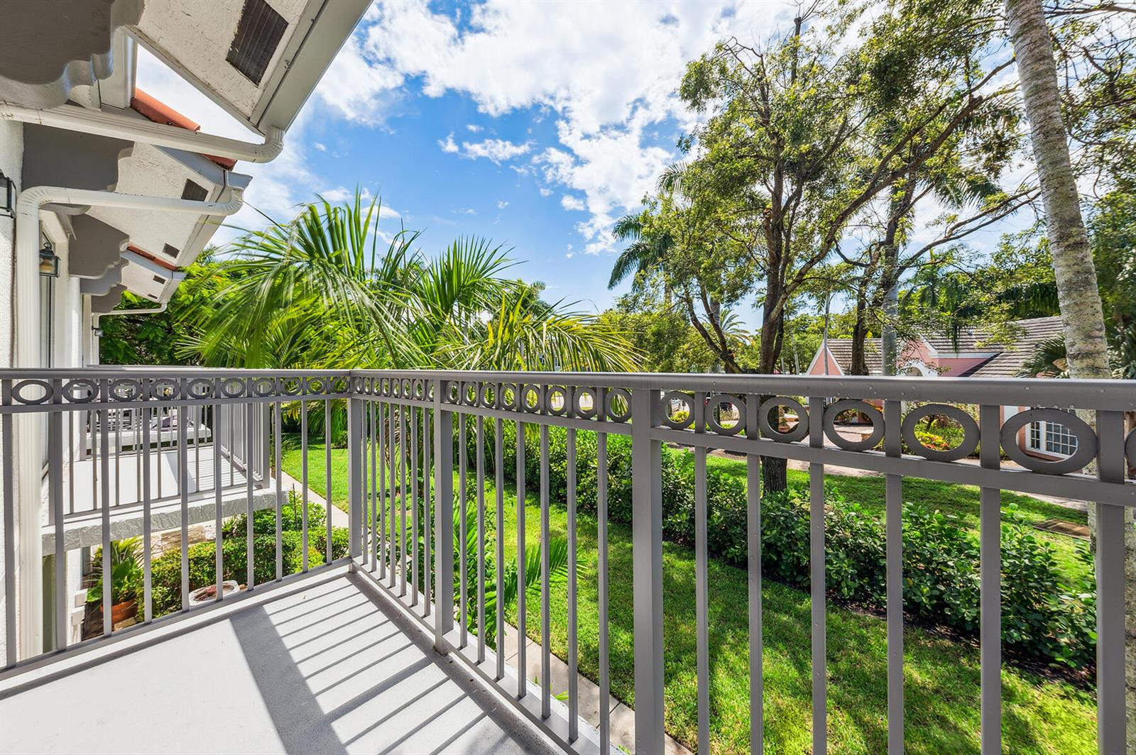 Exterior view of a multi-unit townhouse complex with garages, palm trees, and paved driveways — 2020 Alta Meadows Lane # 504, Delray Beach FL 33444, DELRAY BEACH, FL
