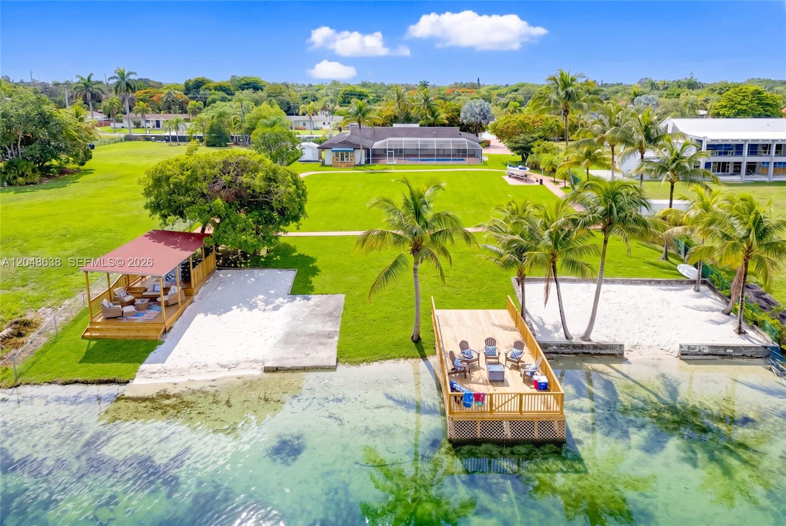 An aerial view shows a waterfront property with a large lawn, dock, and gazebo — 14121 SW 97th Ave, Miami FL 33176, MIAMI, FL
