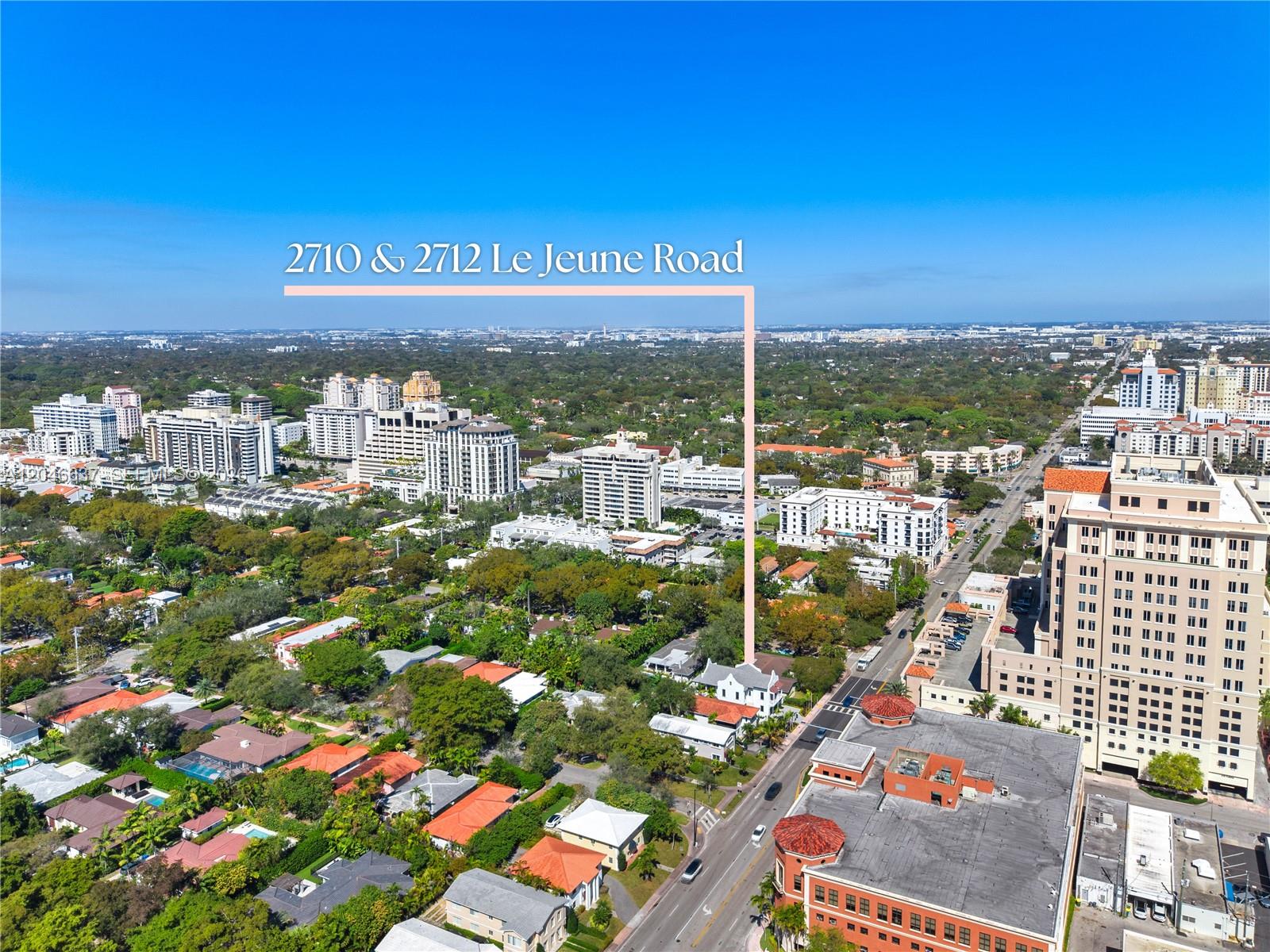 This aerial view shows a residential property highlighted among surrounding buildings and lush trees — 2712 S Le Jeune Rd, Coral Gables FL 33134, CORAL GABLES, FL