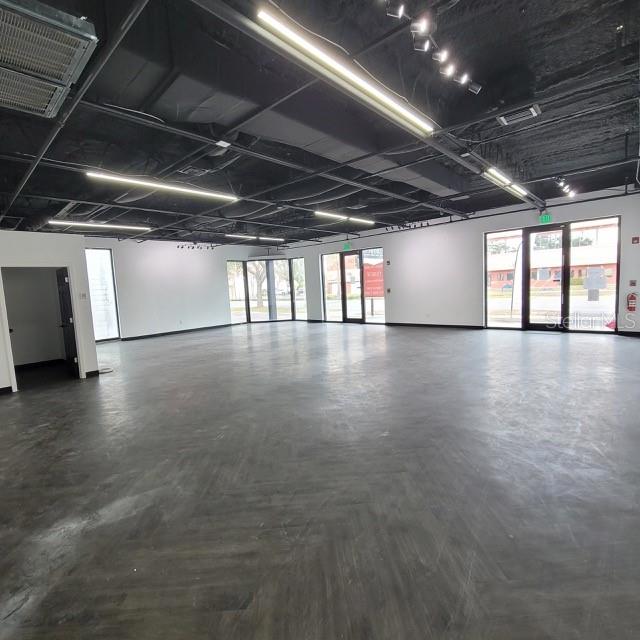 An open commercial space features a dark ceiling, recessed lighting, and gray wood-look flooring — 6124 CENTRAL AVENUE, ST PETERSBURG, FL