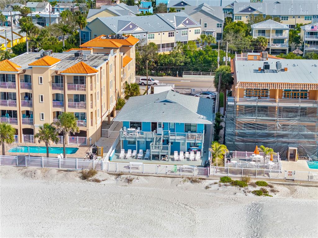 An aerial view shows a blue beach house situated between two larger multi-story buildings — 614 GULF BOULEVARD UNIT 9, INDIAN ROCKS BEACH, FL