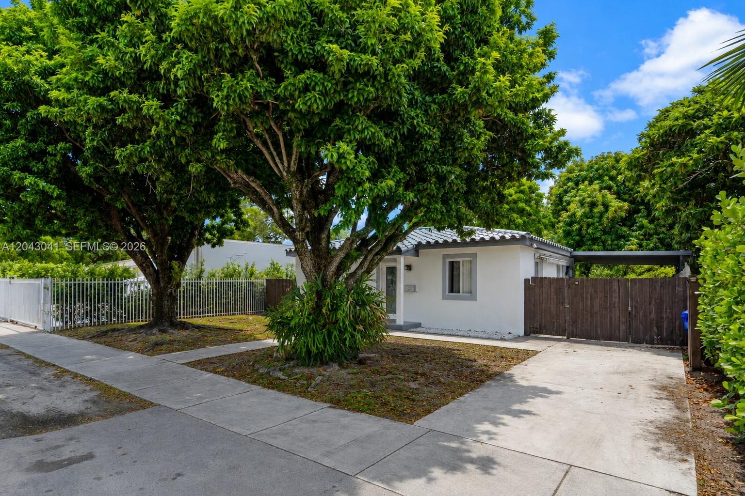 A small white house with a tile roof sits behind a large tree and driveway — 270 NW 51st Ave, Miami FL 33126, MIAMI, FL