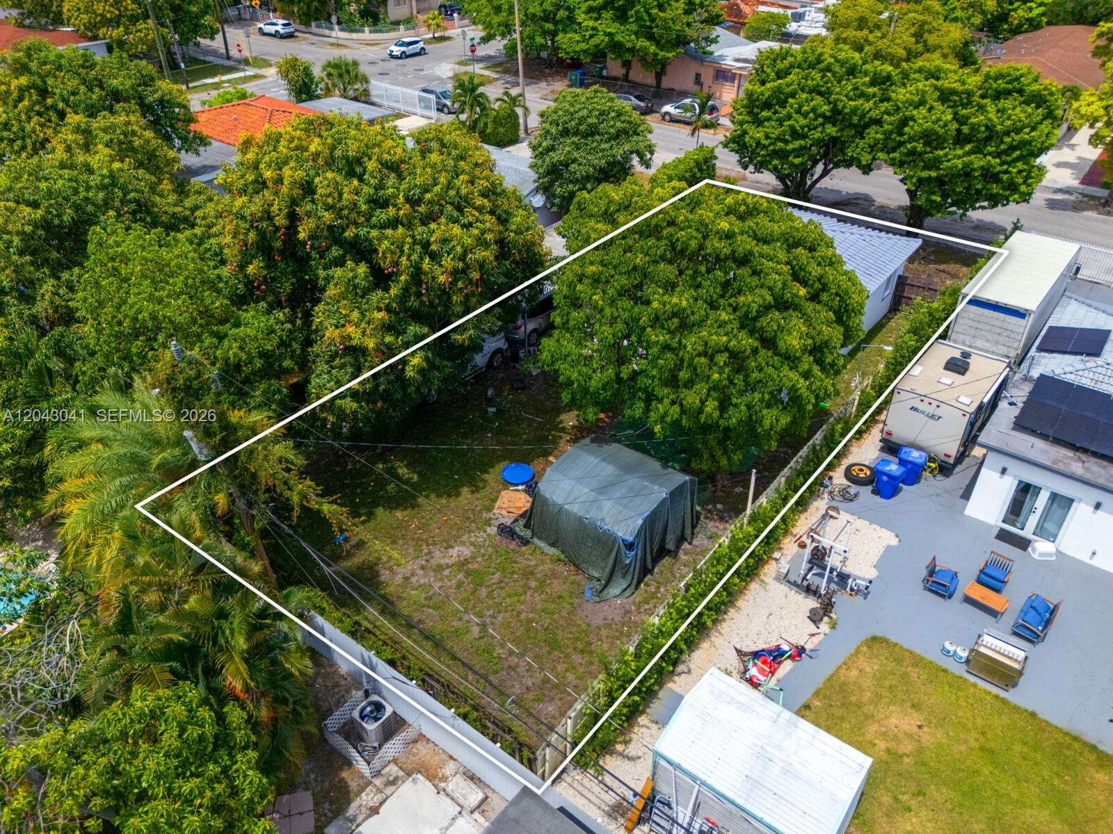 An aerial view shows a fenced residential lot with mature trees and a covered structure — 270 NW 51st Ave, Miami FL 33126, MIAMI, FL