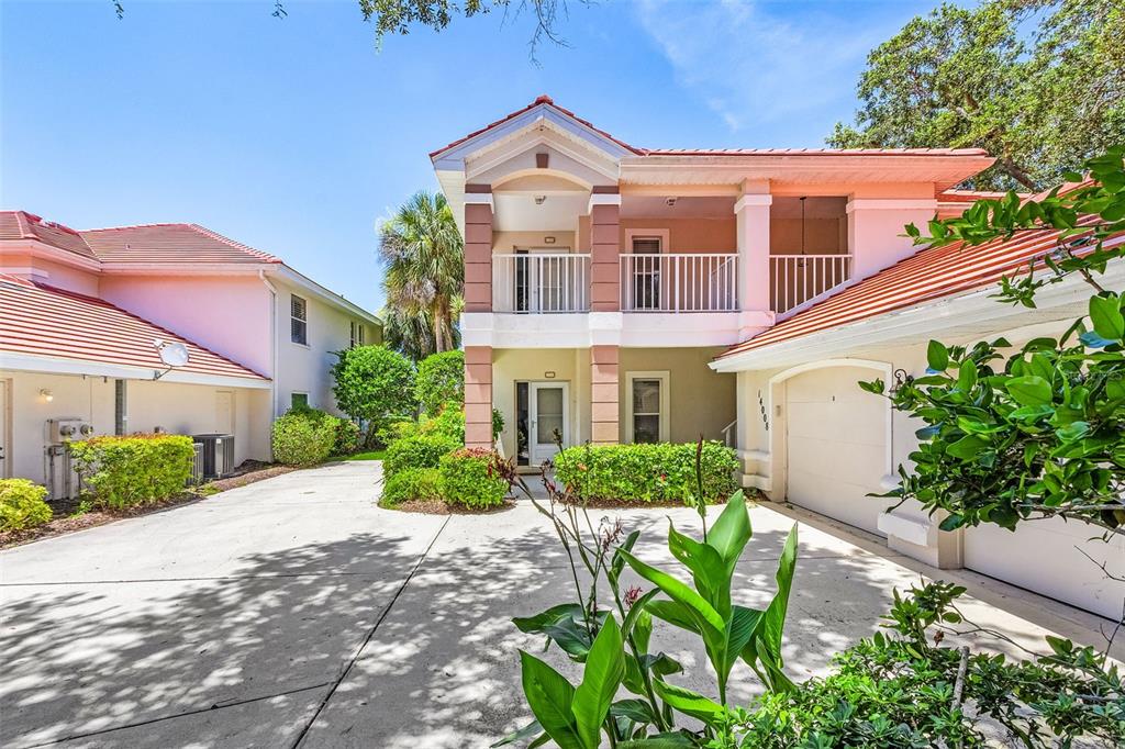 A two-story house with a white garage, a balcony, and a concrete driveway — 14008 WILLOW GLEN COURT UNIT 210, PORT CHARLOTTE, FL