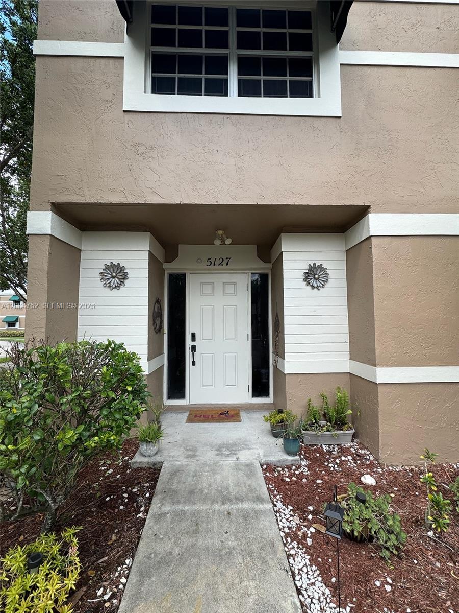 The exterior of a two-story building features a white front door with side windows — 5127 SW 123rd Ave, Cooper City FL 33330, COOPER CITY, FL