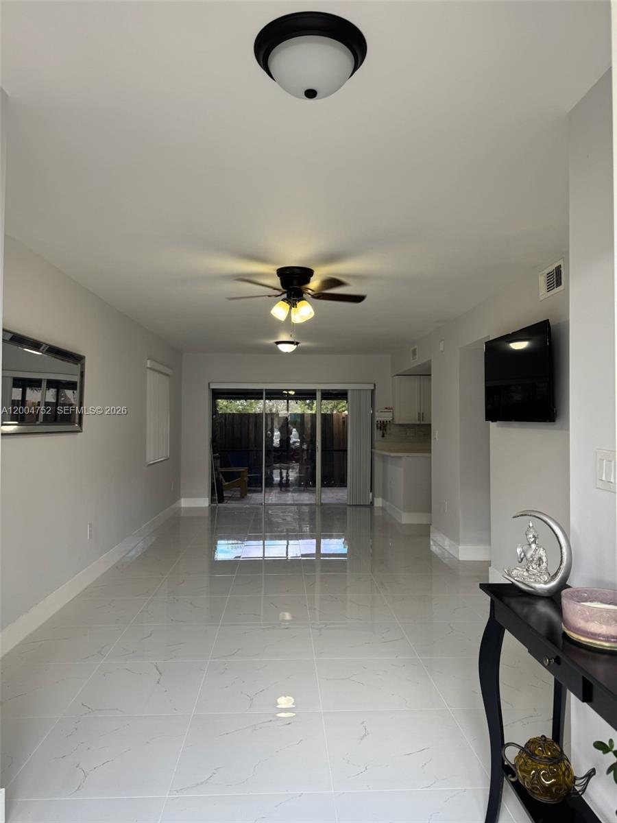 A living room features white tile flooring, a ceiling fan, and sliding glass doors — 5127 SW 123rd Ave, Cooper City FL 33330, COOPER CITY, FL