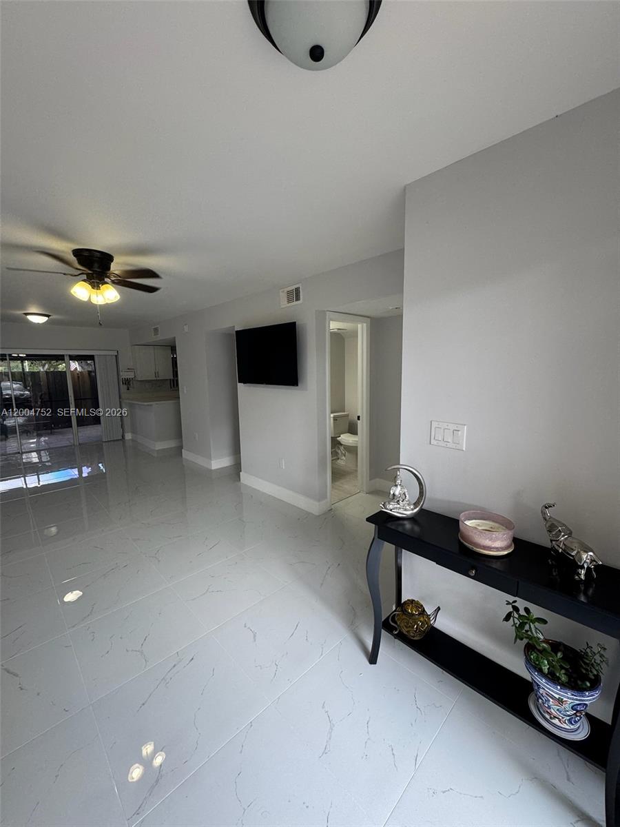 A living area with white marble-look tile flooring, a ceiling fan, and a console table — 5127 SW 123rd Ave, Cooper City FL 33330, COOPER CITY, FL