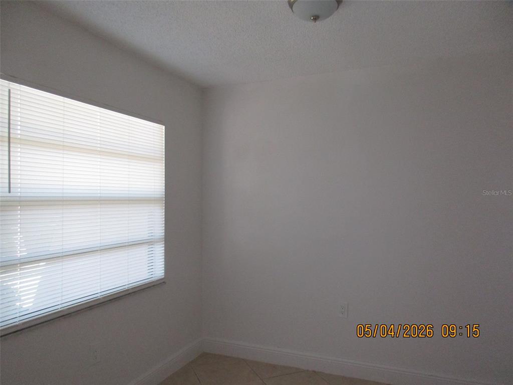 A corner of a room with white walls, a window with blinds, and tiled flooring — 2112 BAHAMAS COURT, KISSIMMEE, FL