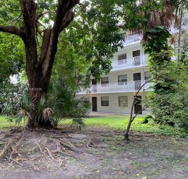 An empty bedroom features white walls, wood-look flooring, a closet with mirrored sliding doors, and a doorway — 500 NE 2nd St # 317, Dania Beach FL 33004, DANIA BEACH, FL