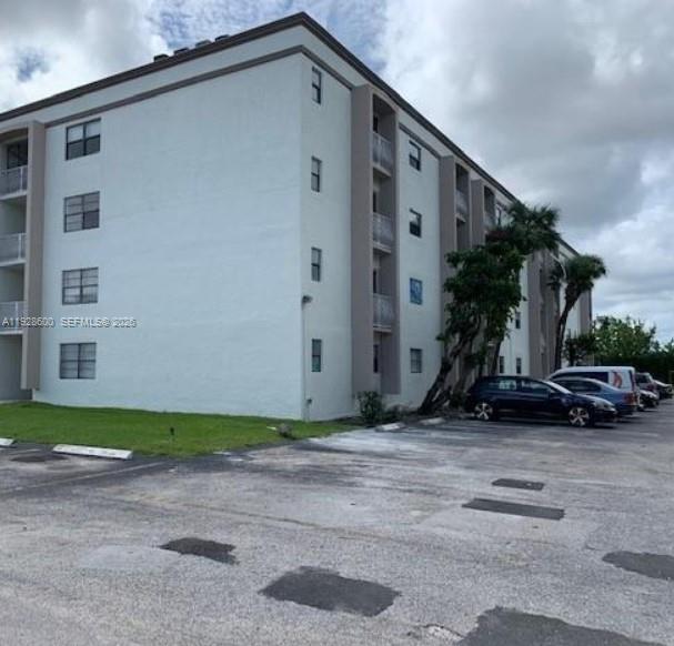 A galley kitchen features wood cabinets, laminate countertops, and a white stove and microwave — 500 NE 2nd St # 317, Dania Beach FL 33004, DANIA BEACH, FL
