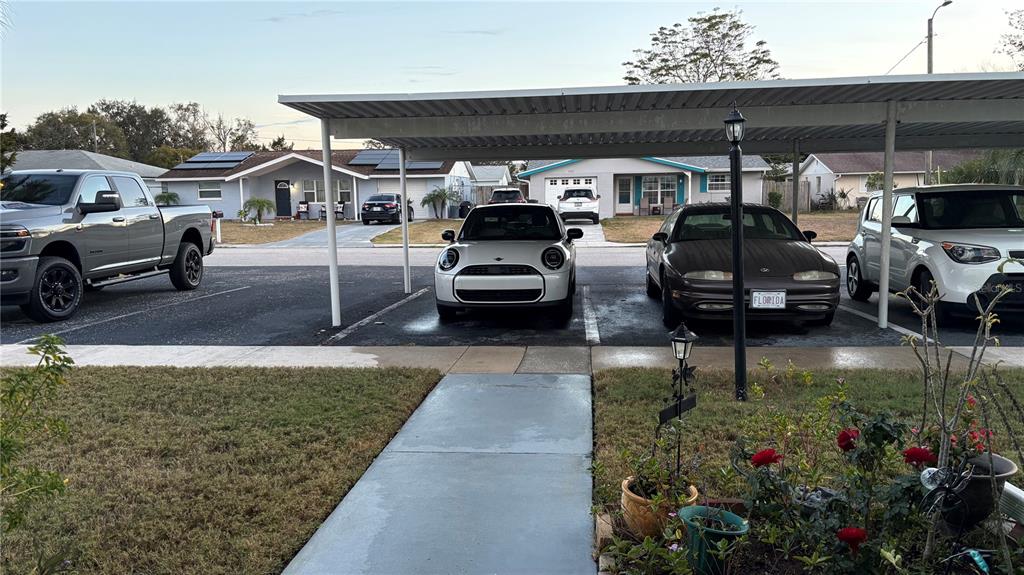 A paved parking area with a metal carport structure covers three parked cars — 5433 PALM DRIVE, NEW PORT RICHEY, FL