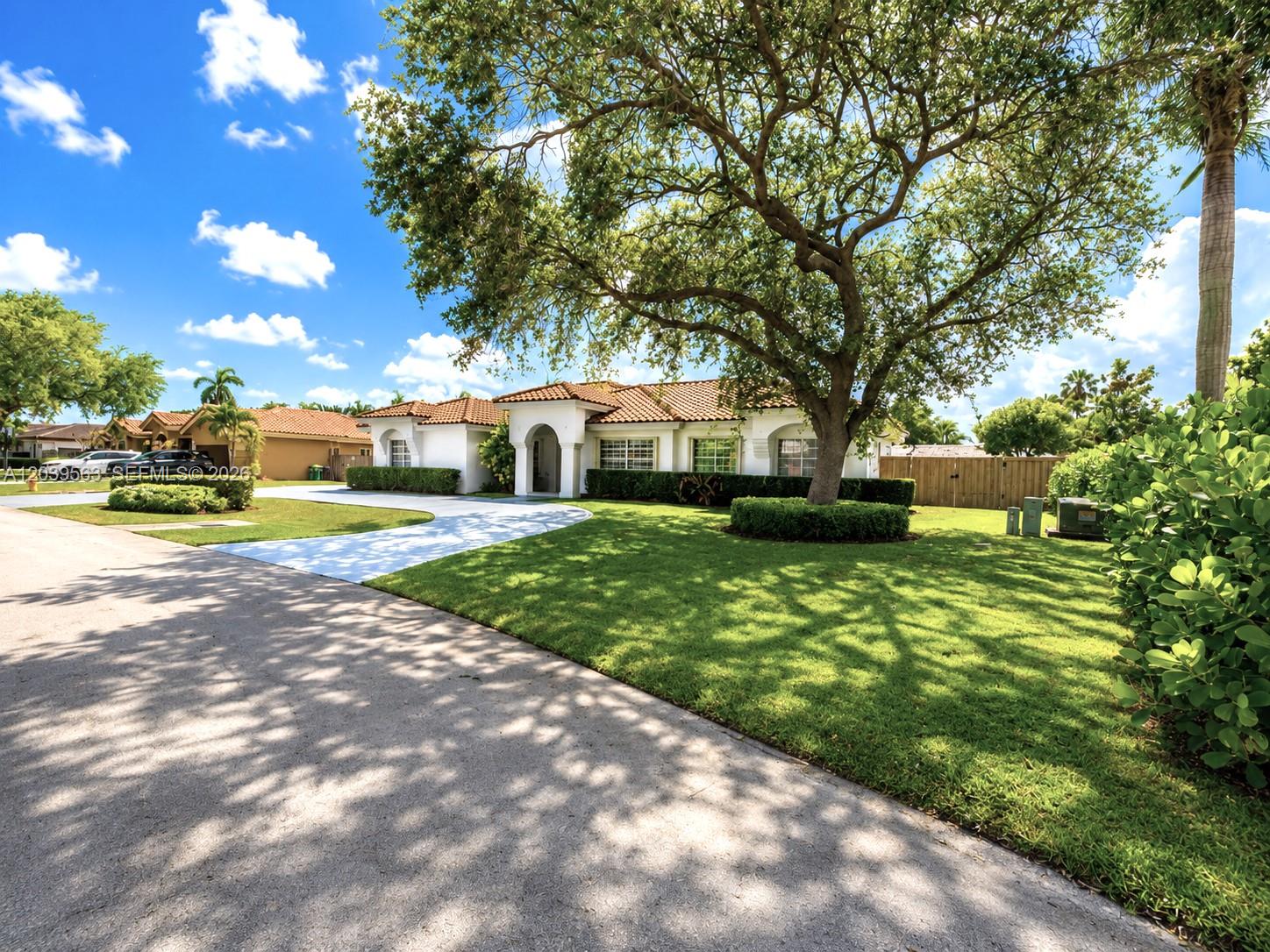 A single-story house with a tile roof and a large tree in the front yard — 15690 SW 153rd Ct, Miami FL 33187, MIAMI, FL