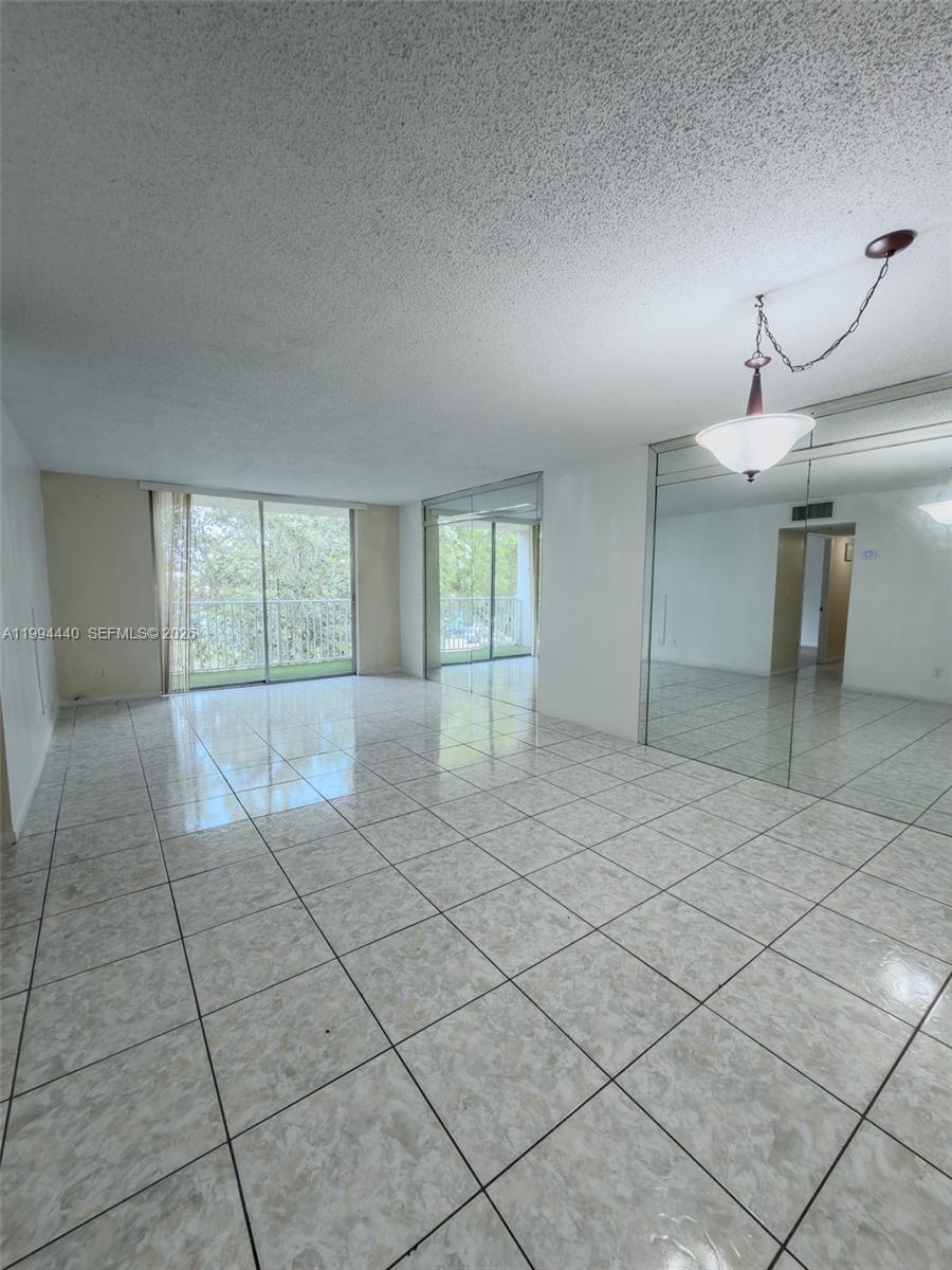 A living room features white tile flooring, mirrored walls, and sliding glass doors to a balcony — 8411 NW 8th St # 301, Miami FL 33126, MIAMI, FL