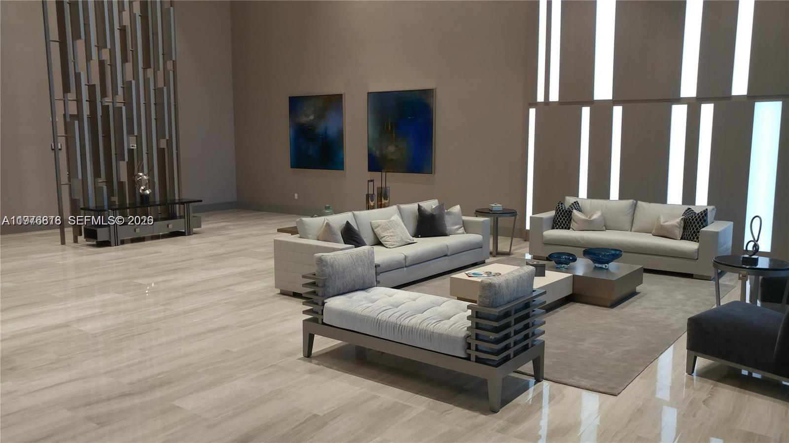 A modern living room features light-colored sofas, a tufted daybed, and large abstract wall art — 5300 PASEO BLVD # 1603, Doral FL 33166, DORAL, FL