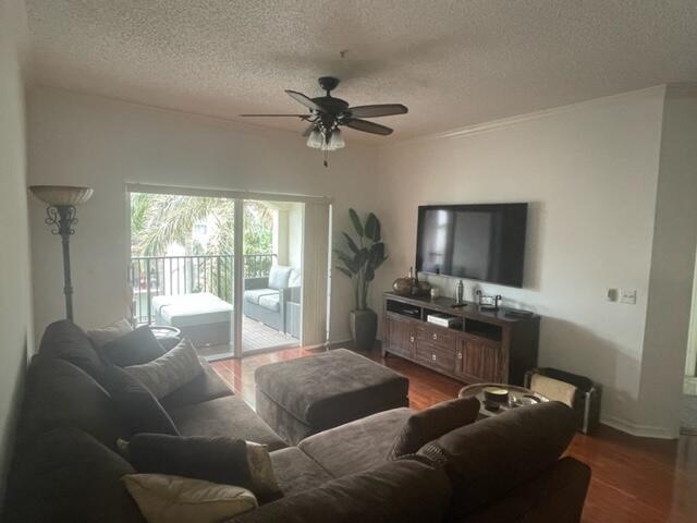 A living room features a brown sectional sofa, a television on a wooden console, and balcony — 3408 Tuscany Way, Boynton Beach FL 33435, BOYNTON BEACH, FL