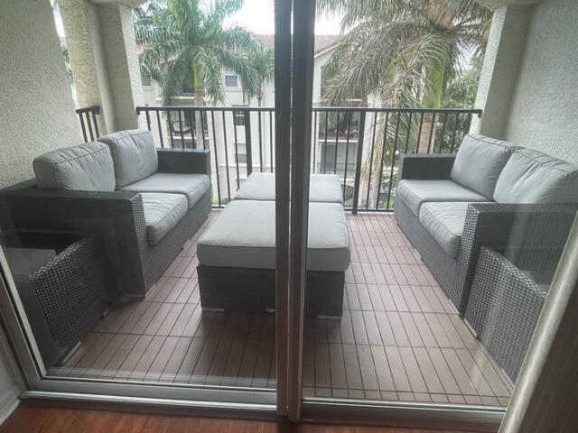 A balcony features two wicker sofas with gray cushions and a matching ottoman — 3408 Tuscany Way, Boynton Beach FL 33435, BOYNTON BEACH, FL