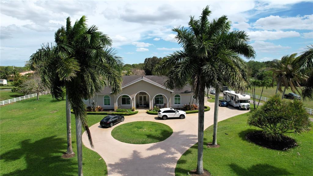 An aerial view shows a single-story house with a circular driveway and palm trees — 4810 SW 198 TERRACE, SOUTHWEST RANCHES, FL