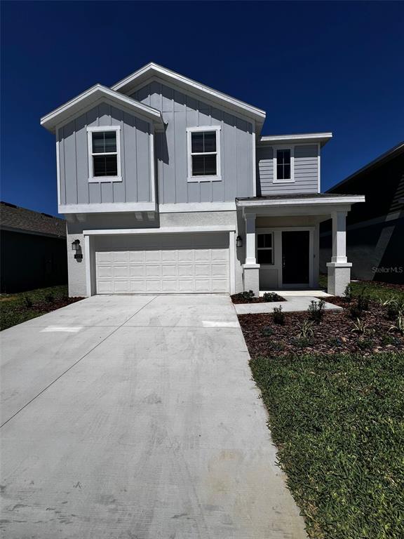 A two-story house with a light gray facade, a two-car garage, and a covered entryway — 433 SANDBAR LANE, HAINES CITY, FL