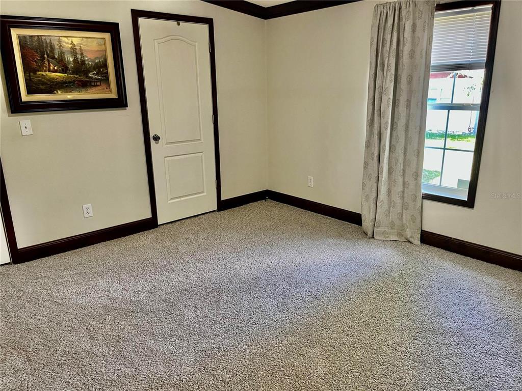 A kitchen with a large island and tile flooring transitions into a carpeted living area — 10452 COUNTY ROAD 136, LIVE OAK, FL
