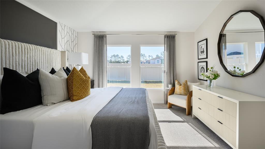 A bedroom features a king bed, a dresser with a mirror, and two large windows — 9249 ORCHARD PARK LANE, DADE CITY, FL
