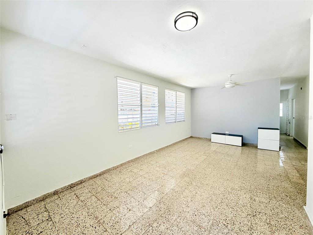 An empty room features white walls, a tiled floor, louvered windows, and a ceiling fan — 0 LIPPTT, SAN JUAN, PR