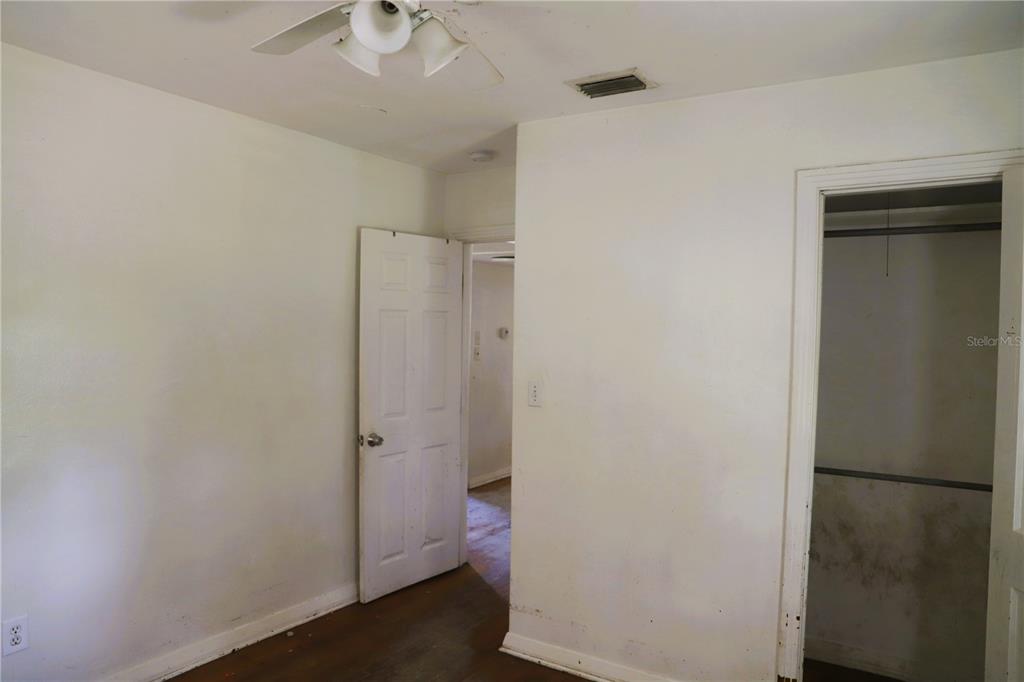 An interior view of a bedroom featuring white walls, a ceiling fan, and a closet — 21514 SE 69TH AVENUE, HAWTHORNE, FL