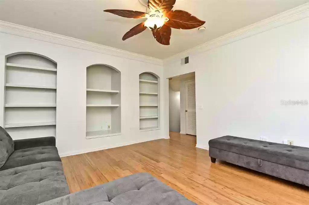 A living room features hardwood floors, a ceiling fan, and three arched built-in wall niches — 265 GOLDENRAIN DRIVE UNIT 265, CELEBRATION, FL