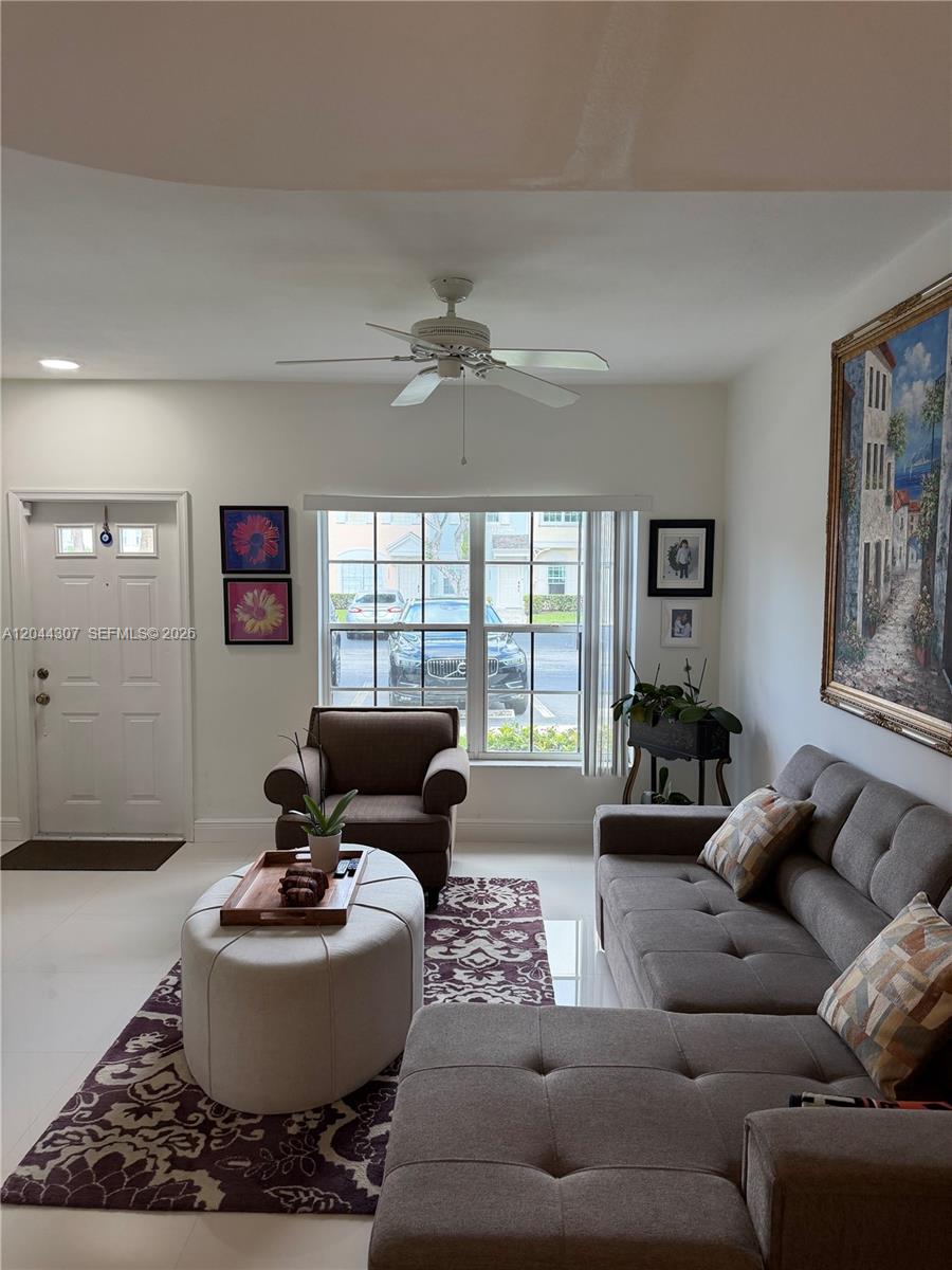 A living room features a gray sectional sofa, an armchair, an ottoman, and a ceiling fan — 16619 Hemingway Dr, Weston FL 33326, WESTON, FL