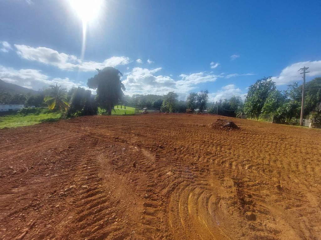 A cleared, graded dirt lot with tire tracks under a bright, sunny sky — BO. QUEBRADA NEGRITO, TRUJILLO ALTO, PR