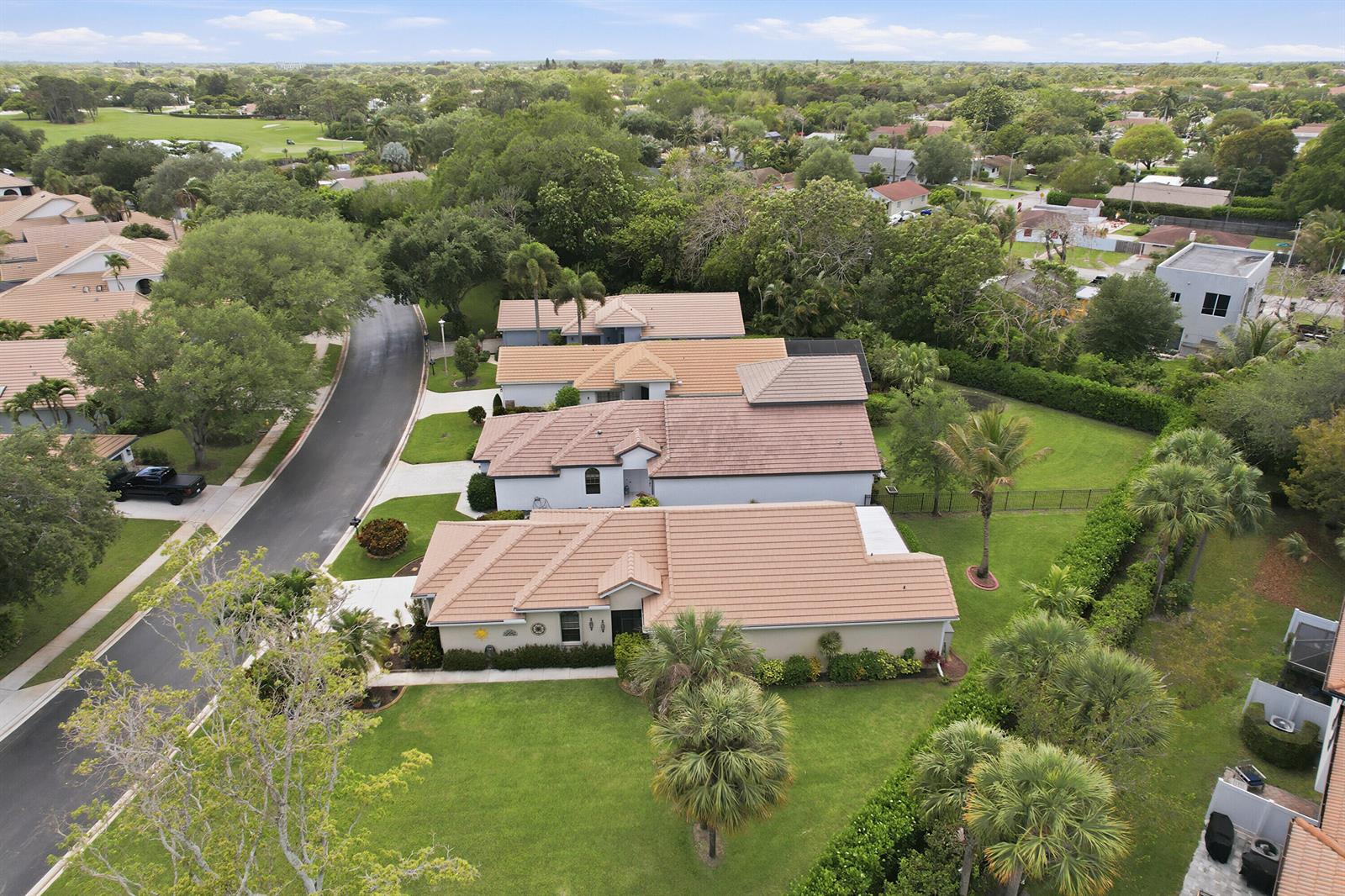 An aerial view shows several suburban houses with tiled roofs and green lawns — 262 Sherwood Forest Drive, Delray Beach FL 33445, DELRAY BEACH, FL