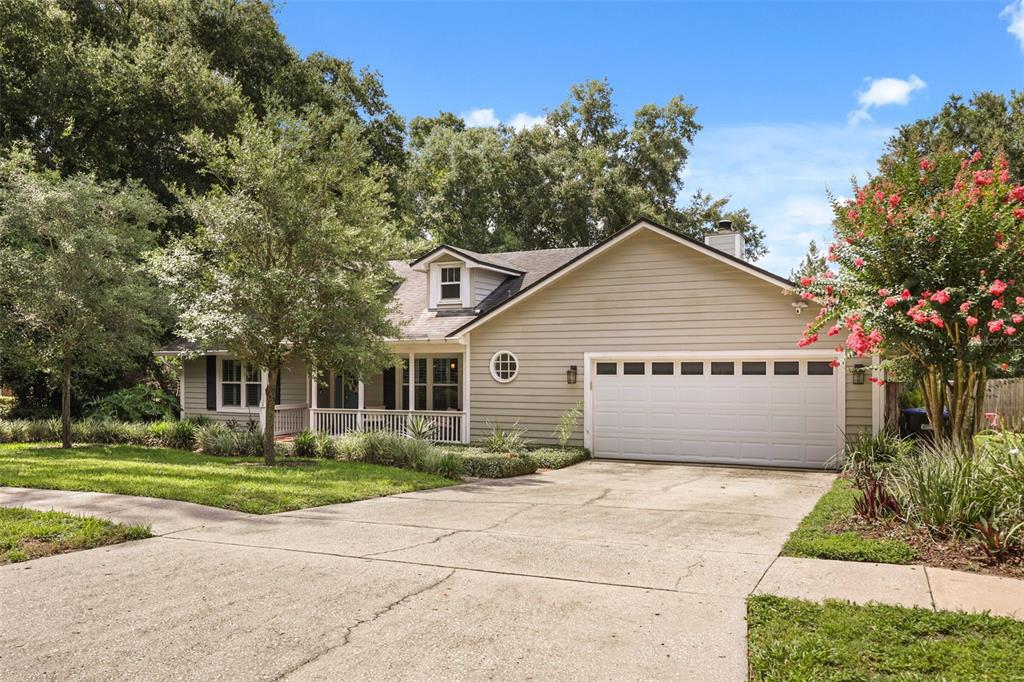 A light green house with a two-car garage, a front porch, and a concrete driveway — 2504 ORCHARD DRIVE, APOPKA, FL