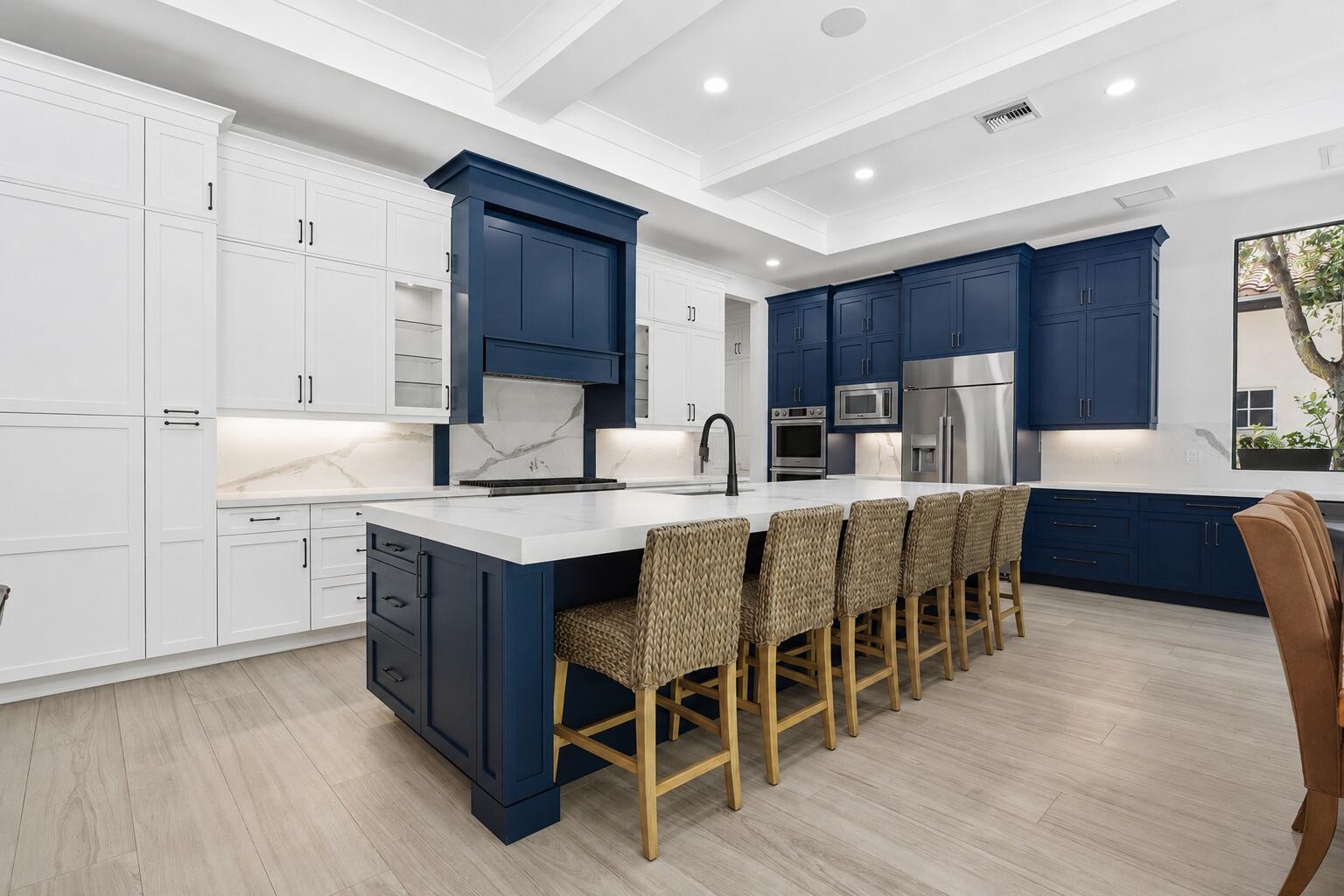 A kitchen features a large blue island, white and blue cabinetry, and light wood flooring — 16075 Tuscany Estates Drive, Delray Beach FL 33446, DELRAY BEACH, FL