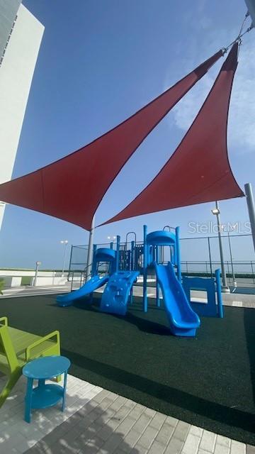 A playground with blue slides and climbing equipment sits under large red shade sails — 16385 BISCAYNE BOULEVARD UNIT 305, NORTH MIAMI BEACH, FL