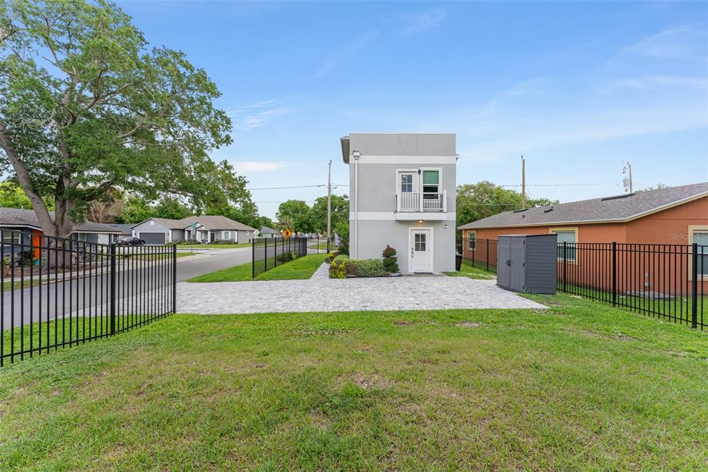A two-story gray building stands on a paved lot behind a black metal fence — 2951 KINGS ROAD, SANFORD, FL