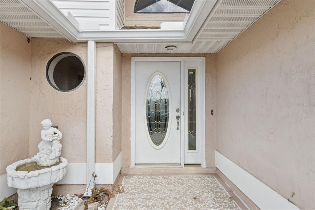The rear exterior of a single-story house features a chimney, a sunroom, and a lawn — 6232 EGRET DRIVE, LAKELAND, FL
