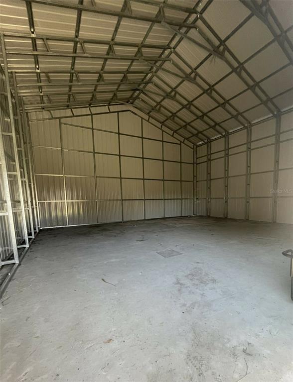 An interior view of a large metal storage building with exposed framing and concrete flooring — 19100 COUNTY ROAD 33, GROVELAND, FL