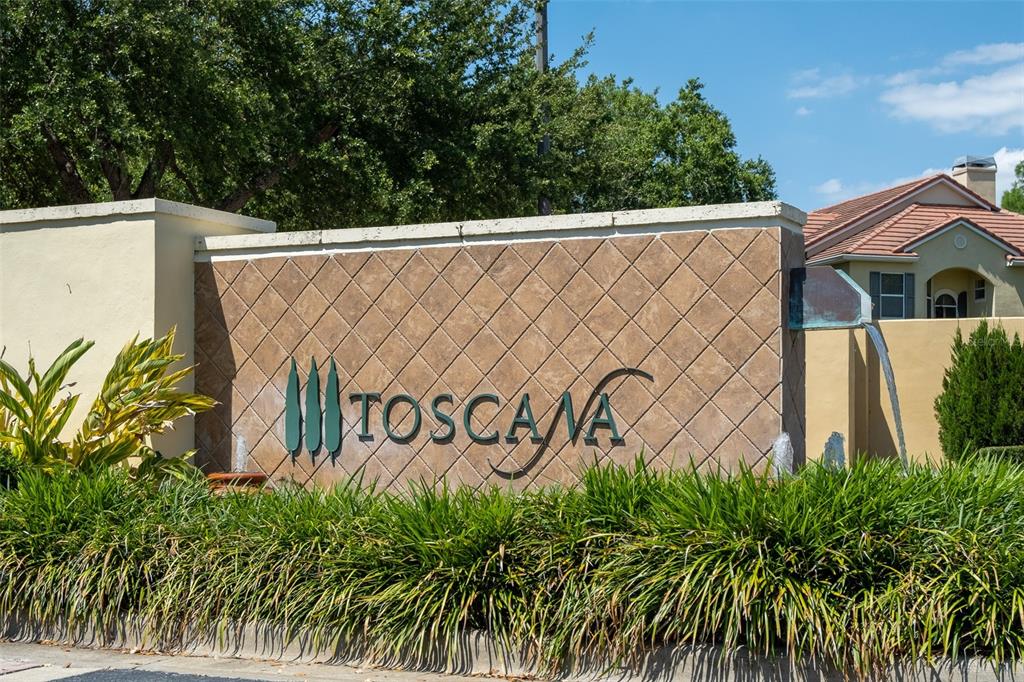 A stone monument sign with the name Toscana sits in front of a residential building — 6959 SORRENTO STREET, ORLANDO, FL