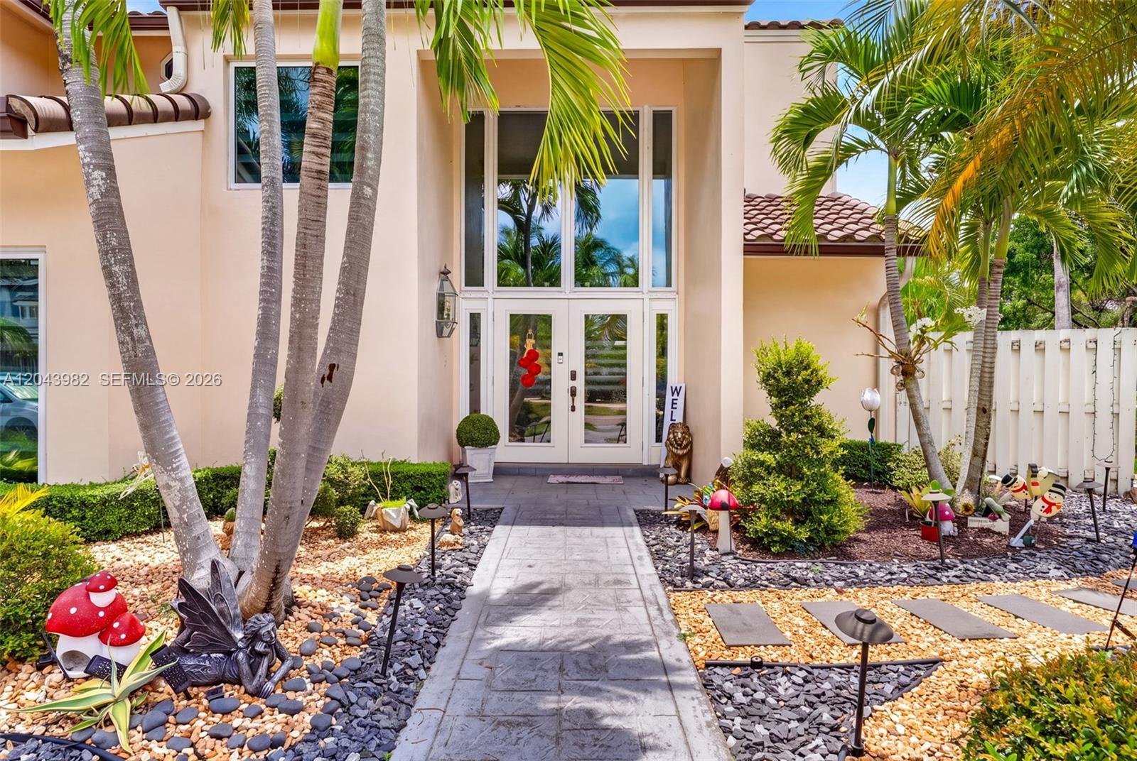 The exterior of a house features a stone walkway leading to a double-door entrance — 962 SW 93rd Ter, Plantation FL 33324, PLANTATION, FL