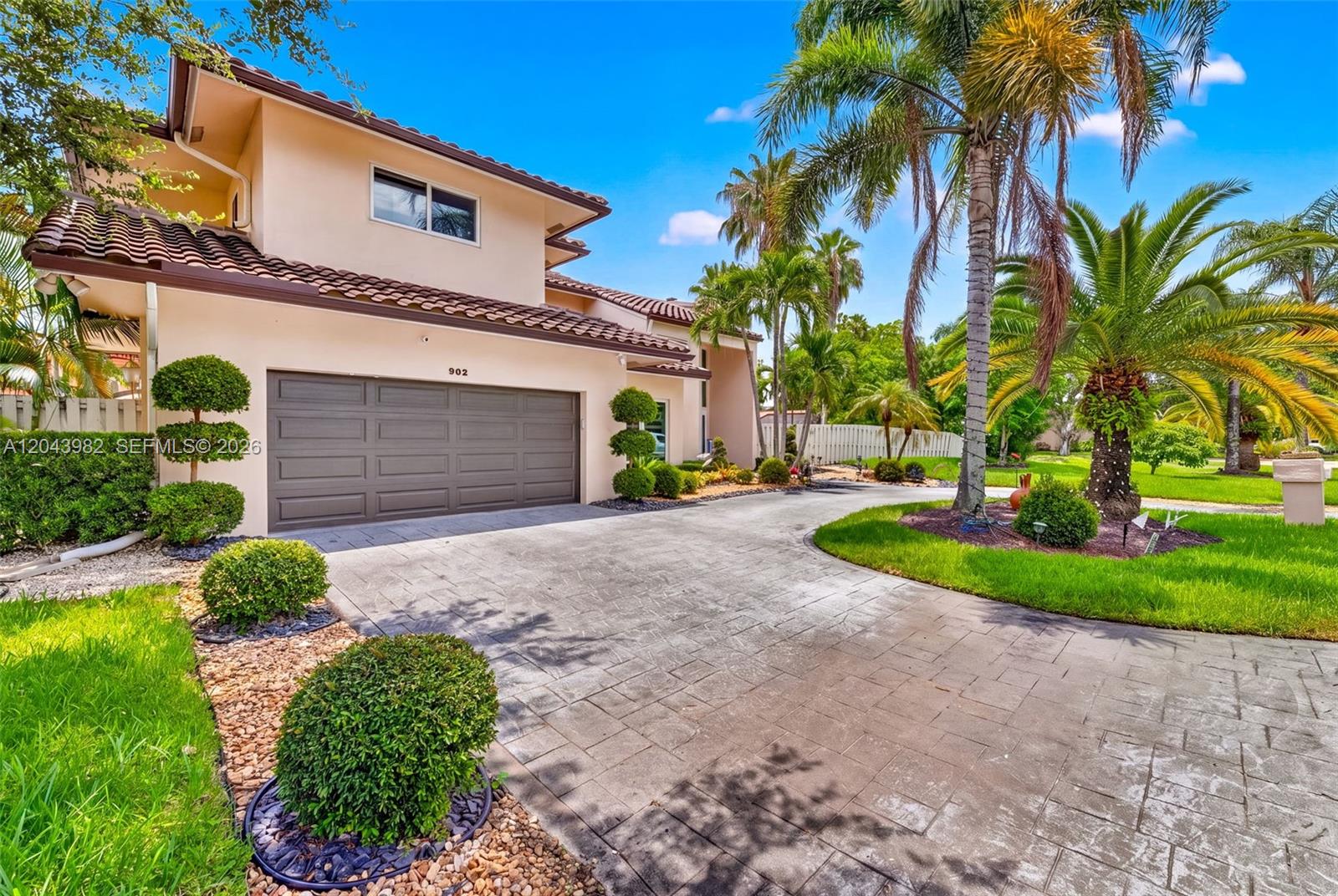 A two-story house with a beige stucco exterior, a tile roof, and a paved driveway — 962 SW 93rd Ter, Plantation FL 33324, PLANTATION, FL