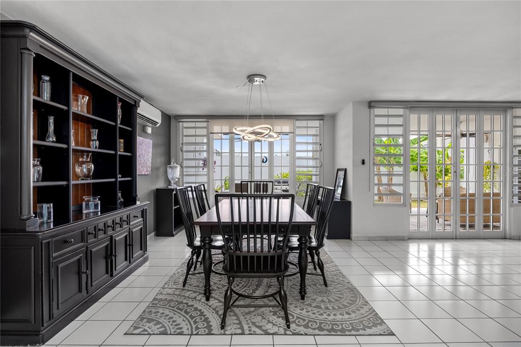A dining room features a dark wood hutch, a table with six chairs, and glass doors — B-31 Poppy Street PARQUE FORESTAL, SAN JUAN, PR