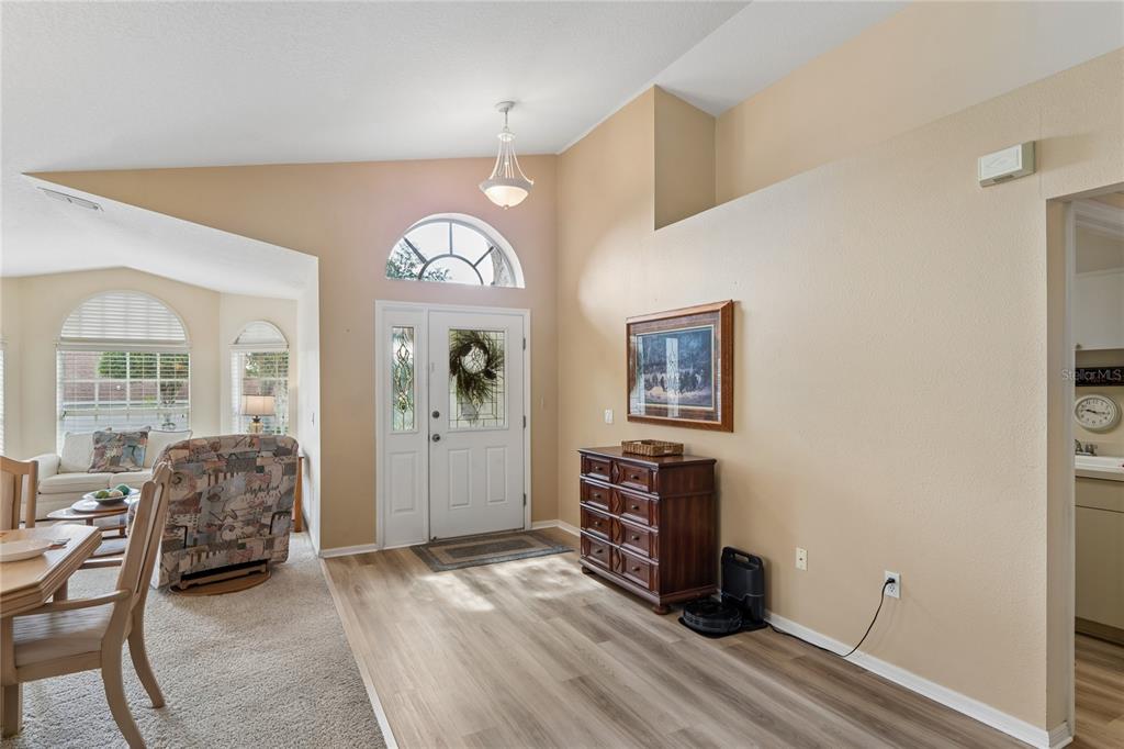 An entryway with light wood flooring, a white front door, and a wooden dresser — 363 QUANE AVENUE, SPRING HILL, FL