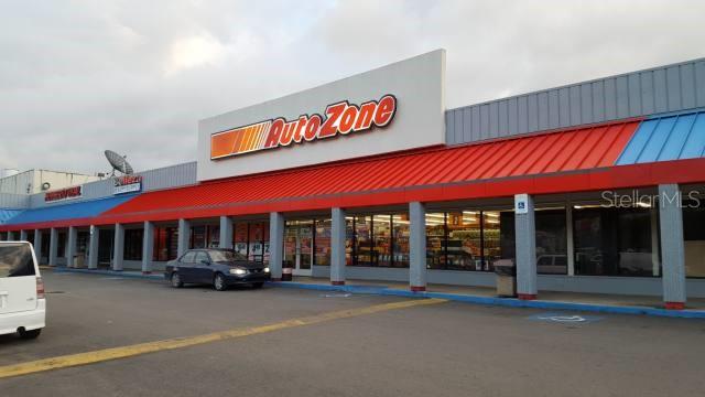 An exterior view of an AutoZone store in a strip mall with a parking lot — PR-111 Km. 20.3 PR-111 KM. 20.3, SAN SEBASTIAN, PR
