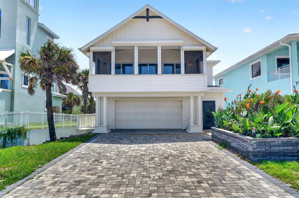 A two-story house with a screened-in porch, a garage, and a paved driveway — 6118 S ATLANTIC AVENUE, NEW SMYRNA BEACH, FL
