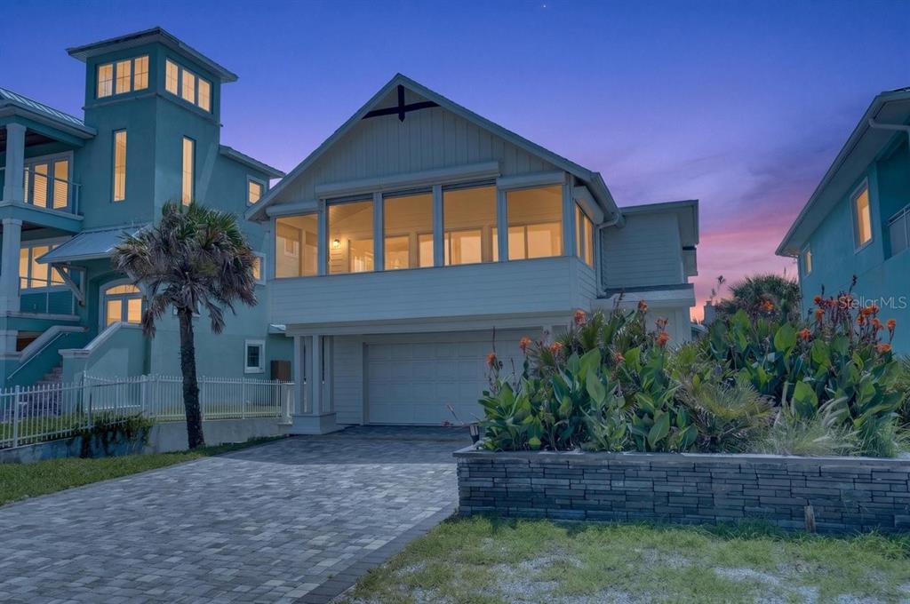 A two-story house with a paved driveway, a garage, and a large screened-in upper porch — 6118 S ATLANTIC AVENUE, NEW SMYRNA BEACH, FL