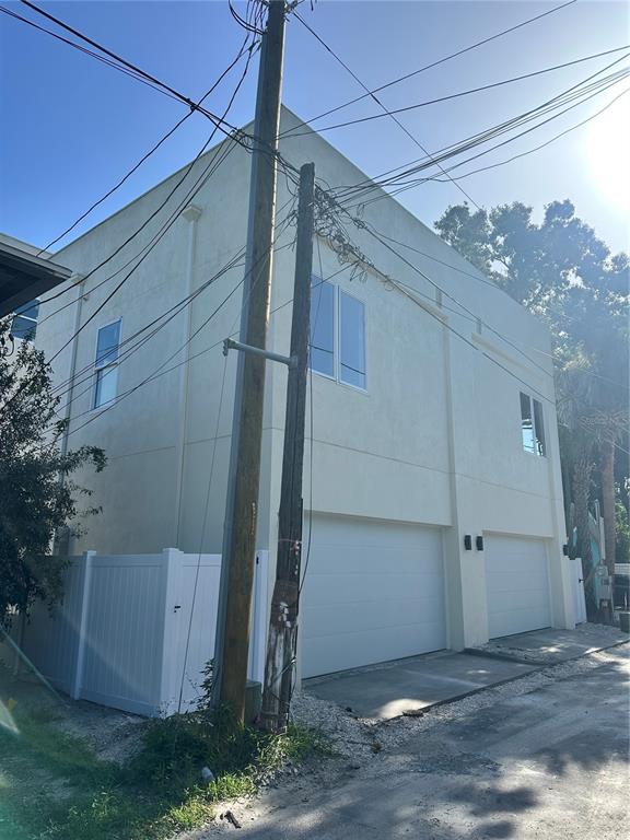 A two-story building with two garage doors and a white vinyl fence — 2142 5TH AVENUE N, ST PETERSBURG, FL
