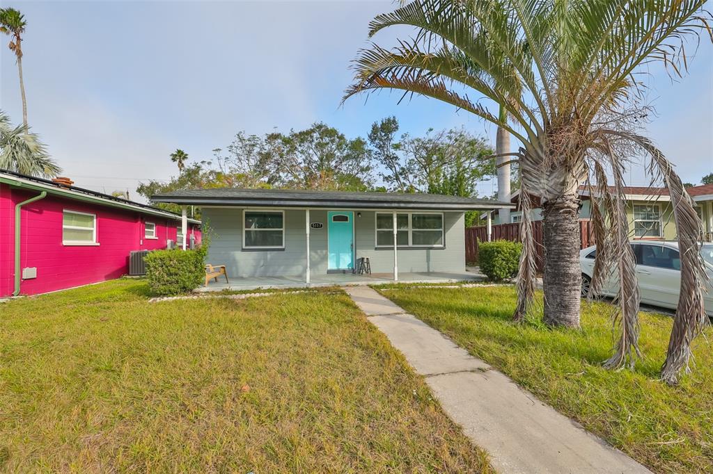 A single-story house with a light gray exterior, a bright blue door, and a palm tree — 5117 12TH AVE S, GULFPORT, FL UNIT 33707, GULFPORT, FL