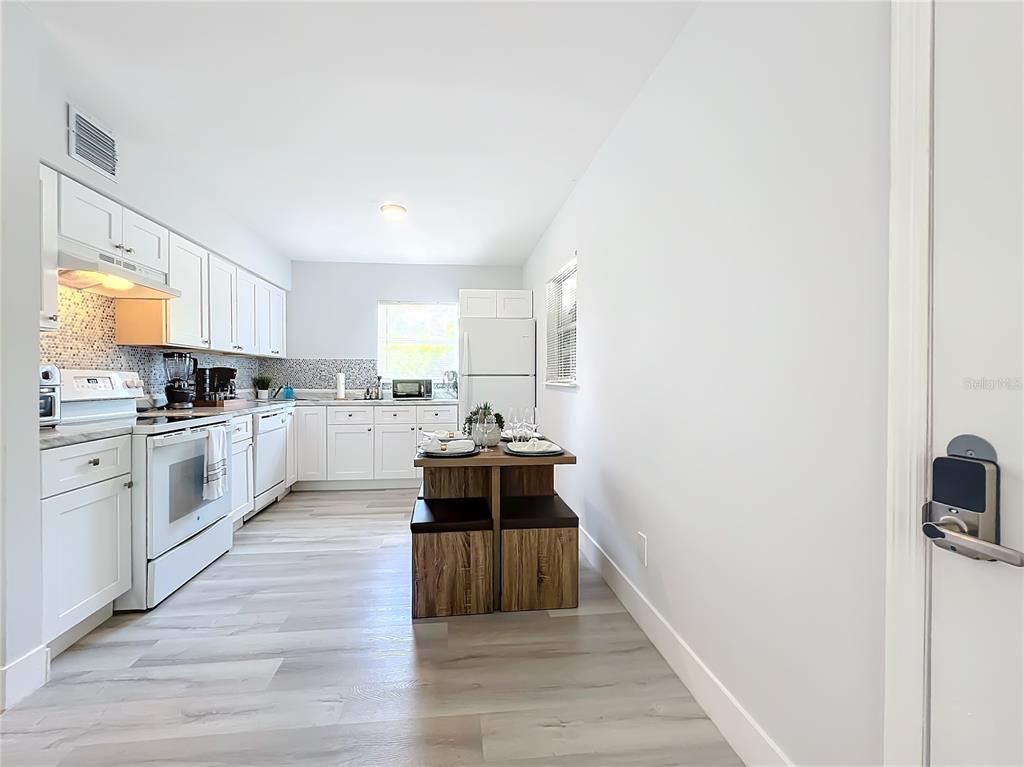 A living room features light gray wood-look flooring, a gray sectional sofa, and a television console — 3025 LONG STREET UNIT A, ORLANDO, FL