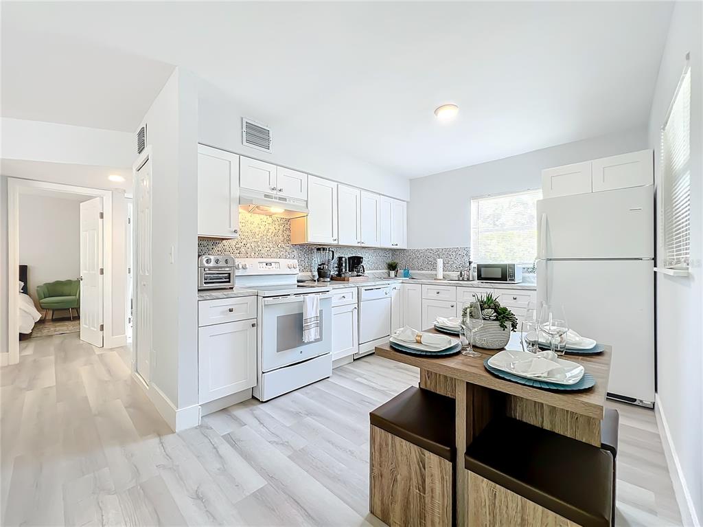 A living room features light gray flooring, a sectional sofa, a rug, and a television — 3025 LONG STREET UNIT A, ORLANDO, FL