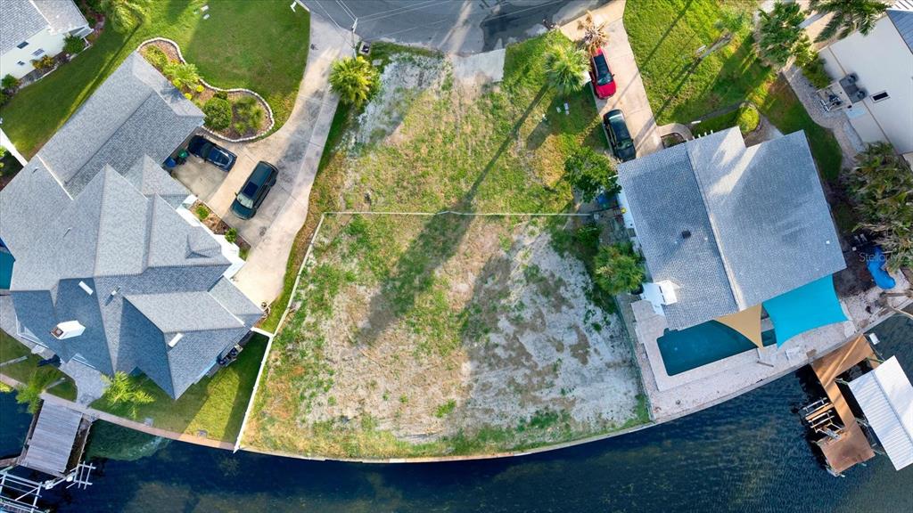 An aerial view shows a vacant waterfront lot situated between two existing residential homes — 121 AUGUSTA AVENUE, PALM HARBOR, FL